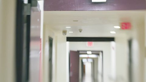 Slow POV walk inside white hospital hallway corridor. Defocused blurred vision.