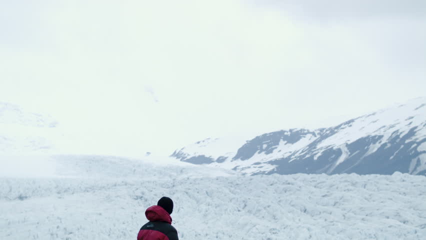 Man exploring wilderness in Iceland hiking near glacier for adventure and freedom with map for orientation