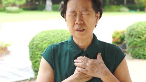 Senior elder Asian woman having heart attack, chest pain