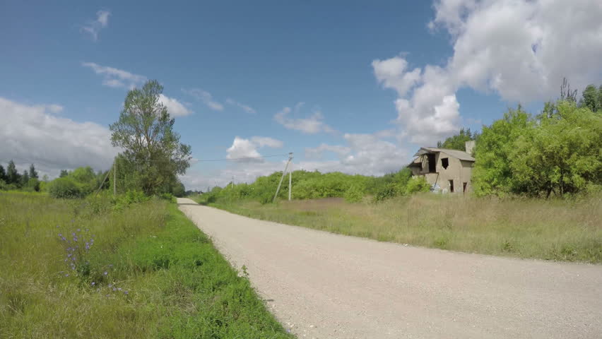 rural gravel road and derelict house ruins with clouds motion. Timelapse 4K

