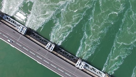 Best Selling HQ Aerial Drone Video (Ultra HD) of the famous Dutch Delta Works. Sunny weather. Opened barriers while traffic passing by. 90 degrees Angle with rotation.