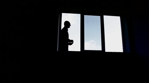 Worried young business man   out of the office window at work