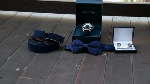 Panning shot of all the groom's clothes (shoes,belt,cuff links,shoes,trousers,shirt,tie) 