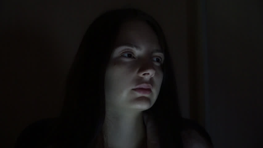 girl rubs his eyes at night