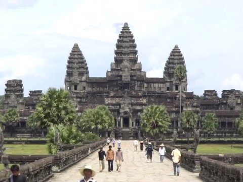 2 shots of Angkor Wat from directly in front with tourists.