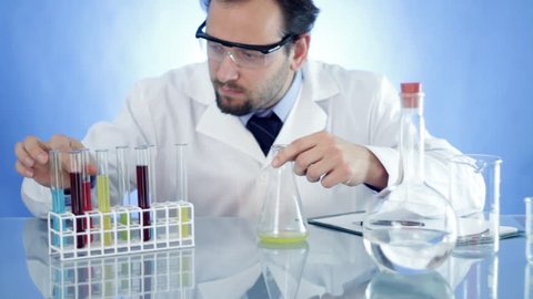 Male scientist mixing chemicals in Erlenmeyer flask and write results in notepad