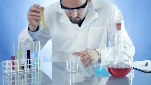 Male scientist mixing chemicals in beaker