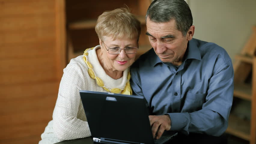 Happy couple working with laptop in the house 