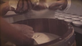 Reproduction Vintage video. Making cheese traditional manually. Clip filtered to look like 1968 super 8 original video and The tools used to make cheese are the same as 60's 