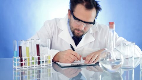 Scientist in laboratory writing in notepad