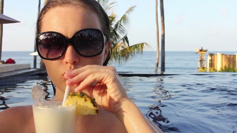 Slider Compilation of a Brunette Sipping a Piña Colada Cocktail in a Tropical Horizon Pool at Sunset