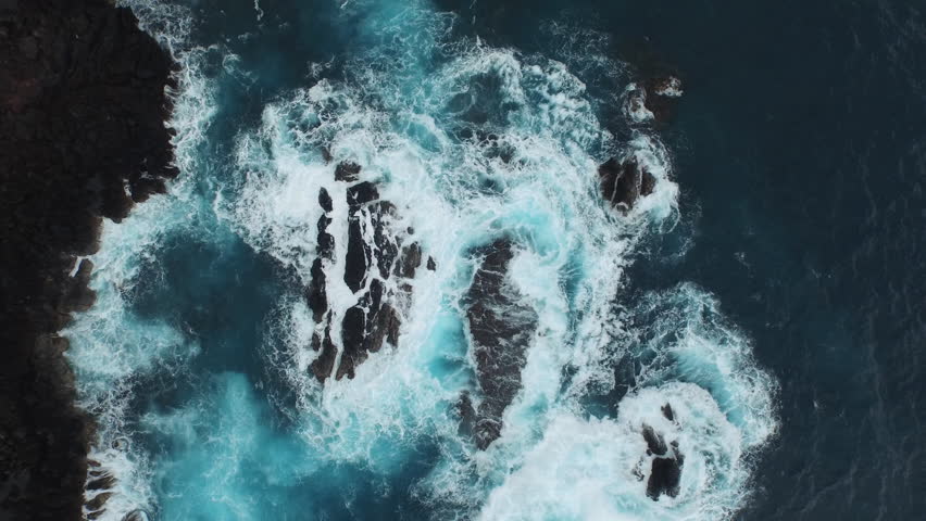 Aerial of the ocean waves washing up on a black basalt rock in Hawaii. Royalty-Free Stock Footage #11290640