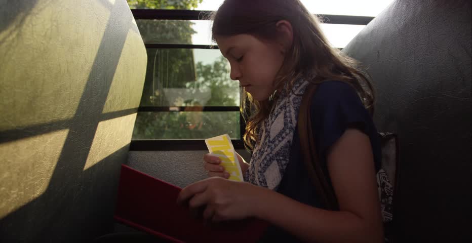 Young girl reading on the school bus