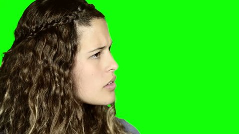 Green screen: Young woman looks to side, listening, is horrified by what she hears, then turns to camera, looking disgusted and nauseated, shaking her head.