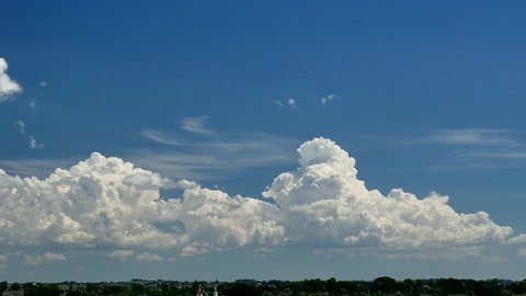 Developing Thunderstorms. Cumulus clouds build into congestus and then small cumulonimbus with anvils on a hot summer day.