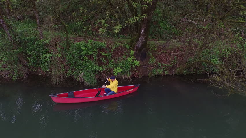 Aerial shot of man paddling canoe in lake