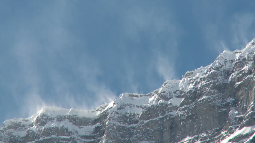 Snow spindrift blowing off mountain peak