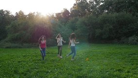 Three friends, young girls, having fun in park, running, laughing, slow motion.