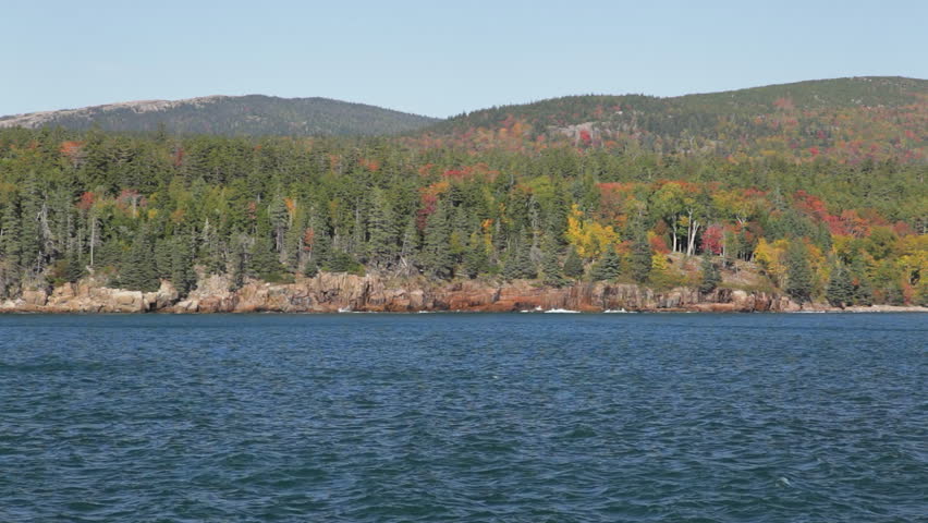 Locked down view of the rocky, forested west shore of Otter Cove in Acadia National Park, Maine in Autumn.