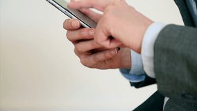 Tilt up shot of businesswoman's hands scrolling on smart phone. Female executive is scrolling and zooming.