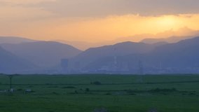 Green Fields Next to Industrial Plant. A great piece of stock footage filmed in 4k definition, perfect for film, tv, documentaries, reality TV, trailers, infomercials and more!