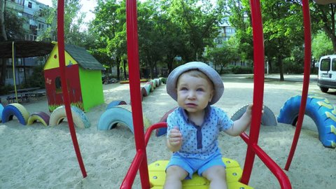 Child boy on swing in yard