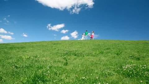 happy family down meadow with green grass and wildflowers 