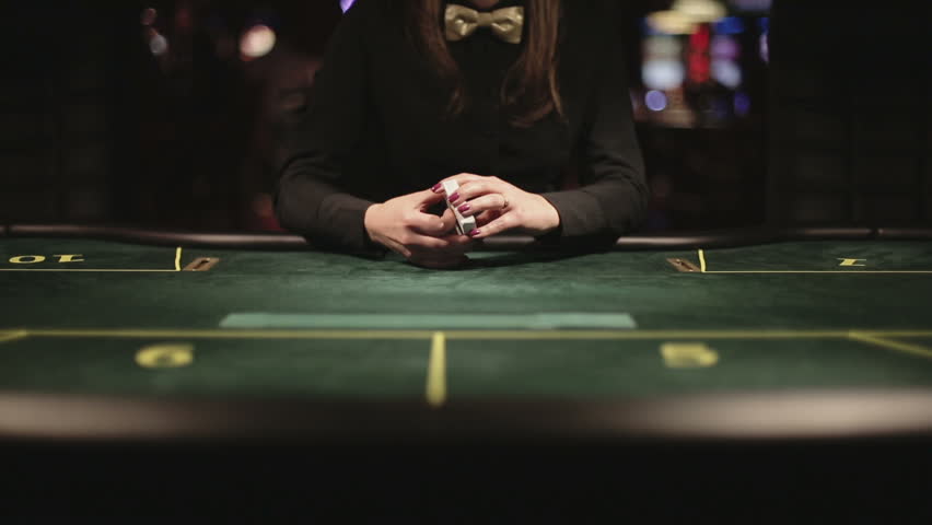 Poker dealer shuffling playing cards fanning out the deck on the table