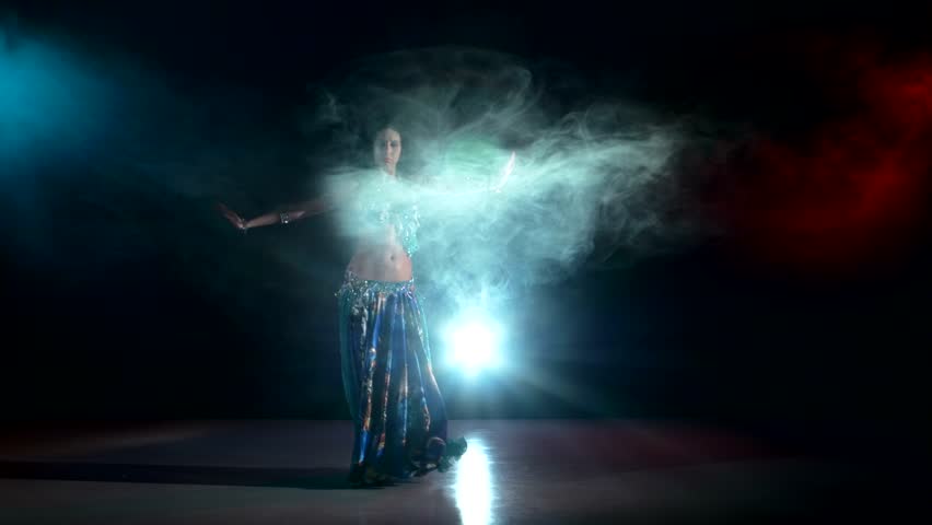 Beautiful, exotic, dark long-haired, belly dancer girl continue dancing and exotic dance on black, smoke, background, back light | Shutterstock HD Video #11332316