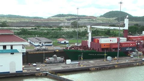 PANAMA, CIRCA OCT, 2014: Cargo vessel passes the non-navigable water. The Panama Canal is a ship canal in Panama that connects the Atlantic Ocean (via the Caribbean Sea) to the Pacific Ocean.