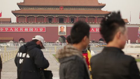 Tiananmen Square, Beijing - November 2010: Young Chinese men in Tiananmen Square with the Portrait of Chairman Mao on the Tiananmen Gate in the background. Beijing, China.