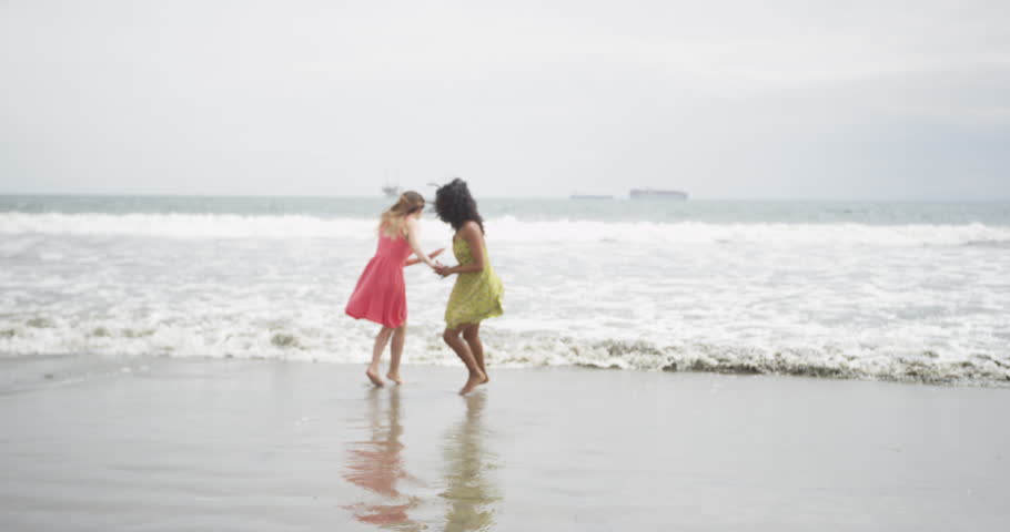 Cute Women runing away from the tide at the beach