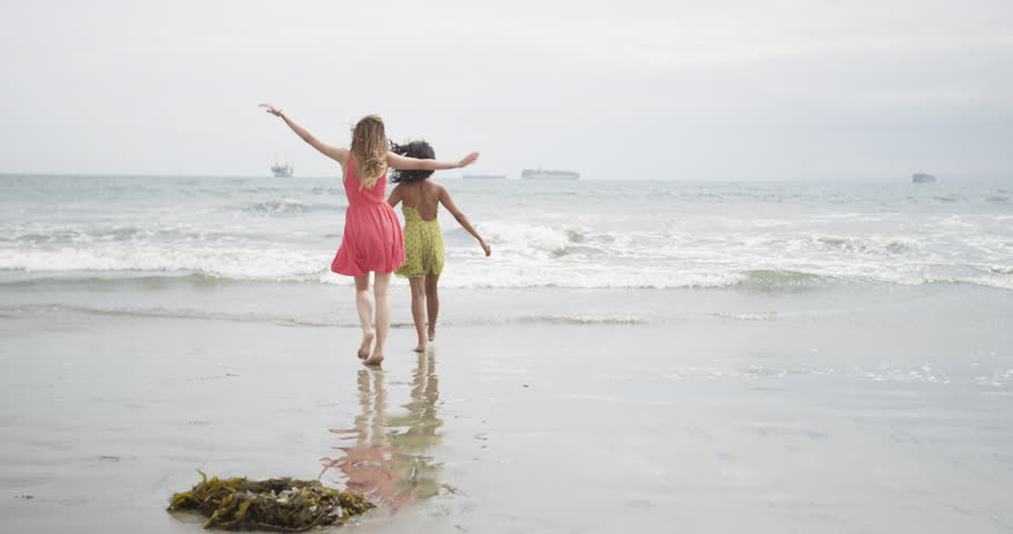 Women runing away from the tide at the beach
