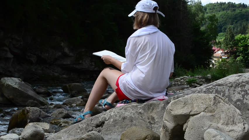 The girl draws the mountain river and the rock