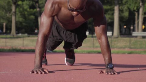 Muscular Athlete does clapping pushup in super slow motion