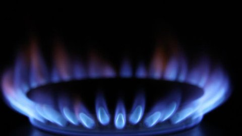 A gas burner igniting with a clean blue flame