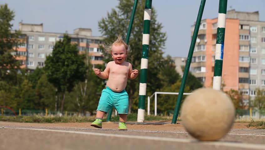baby learning to play football at the stadium