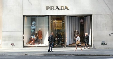 NEW YORK CITY -  MAY 14, 2015: People and traffic in front of Prada store on 5th avenue. The Italian fashion company is present in 65 countries with 250 single brand shops. It was founded in 1913.