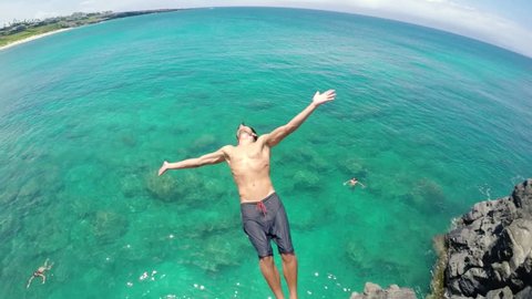 Young Man Back Flips off Cliff Into Water. Summer Extreme Sports Fun Lifestyle. (Slow Motion)