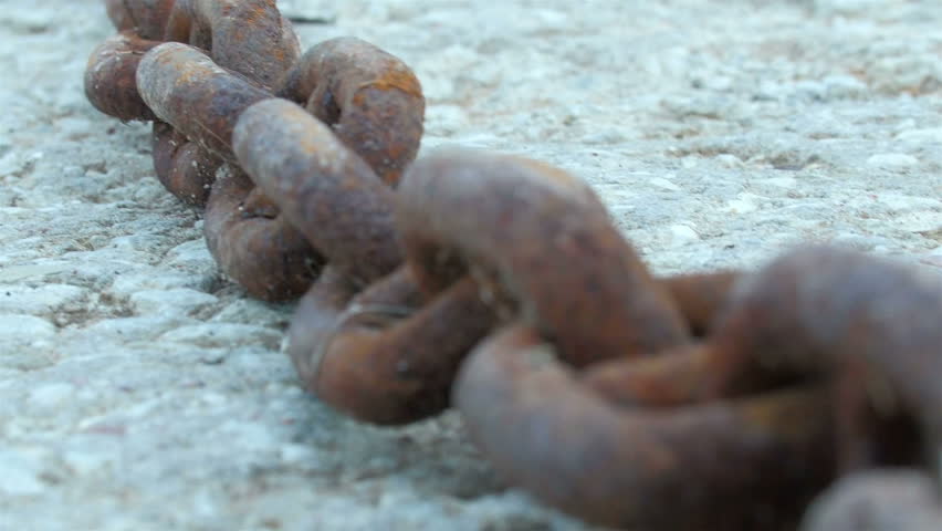 A red big chain from a big anchor of a ship. It is a rusty chain on the rocky ground in a small port | Shutterstock HD Video #11389283