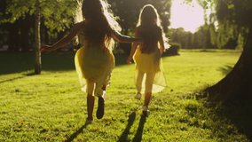 Two Girls are Running Away in Sunlight at Park. Shot on RED Cinema Camera in 4K (UHD). - Powered by Shutterstock - Get 15% off with code: PIKWIZARD15