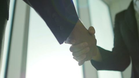 Two business partner shake hands when meeting. In slow motion