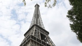 Steel construction of Eiffel tower located in Paris France and clouds 4K 2160p 30fps UltraHD tilt footage - Slow tilting on French Eiffel tower in font of cloudy sky 4K 3840X2160 UHD video