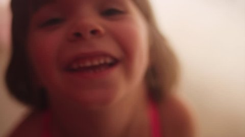 An extreme close up of a little girl smiling at the camera