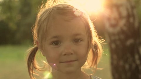 Portrait Adorable Little Girl Smiles outdoor at sunset