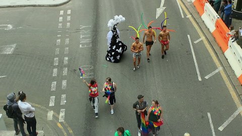 Birmingham Gay Pride 2015 - view from above - Twiggy lights a cigarette with help of a muscular, semi naked guy.Twiggy is one of the Midlands' most well known and outrageously flamboyant drag artists.
