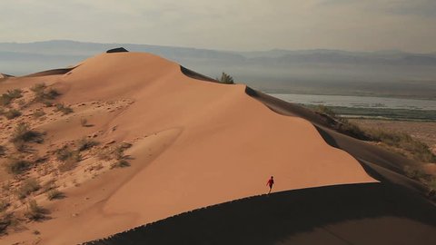 Unrecognizable man ascent on the sand dune in the desert. Canon 5D Mk II.