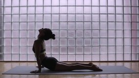 Woman practicing yoga in a studio indoors. 
