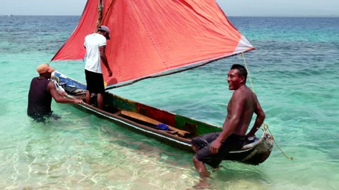 PANAMA, JUNE 2015 - Kuna Indians, native people, indigenous peoples, men fishing on sailing boat, fishermen on traditional dugout canoe with sail. Isla Aguja, archipelago of San Blas islands, Panama