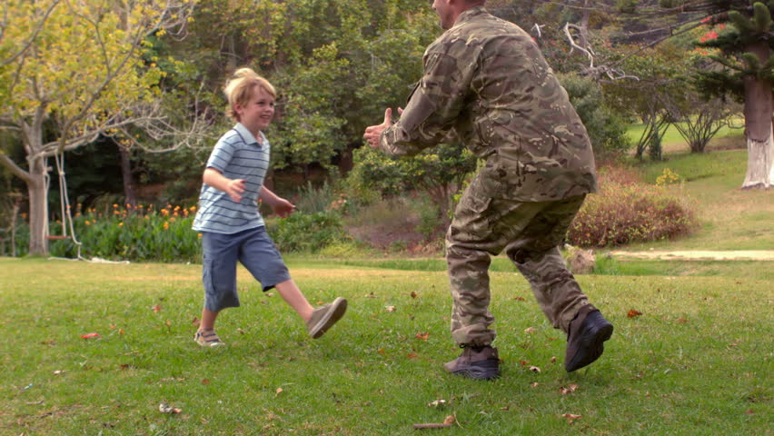 Side view of happy Caucasian man soldier reunited with his son who throw himself in his dad's arms on a sunny day Royalty-Free Stock Footage #11459330
